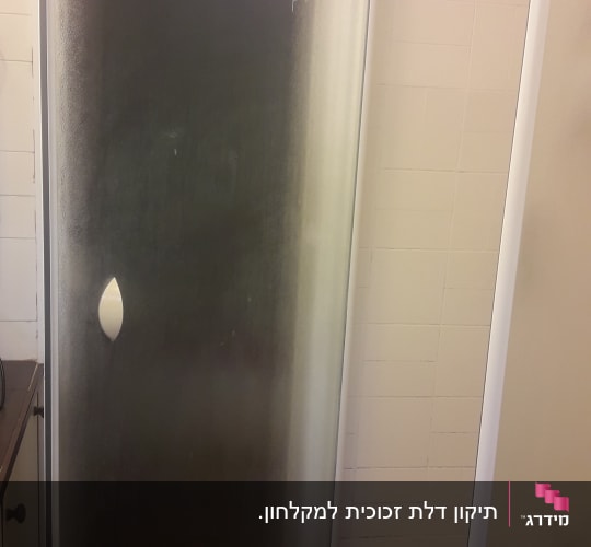 התקנת מקלחון זכוכית מחוספסת עם דלת נפתחת בחדר רחצה